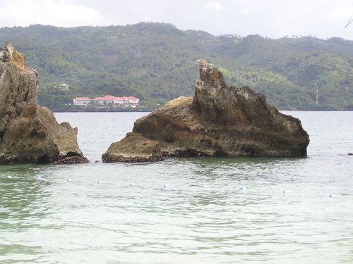 A large rock in the middle of a body of water