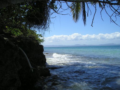 A view of the ocean from a cliff on a sunny day