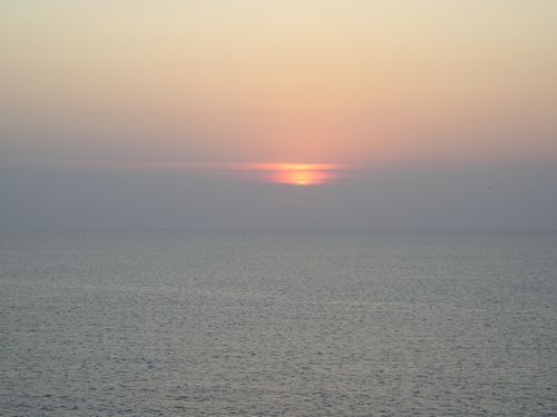 The sun is setting over the ocean.