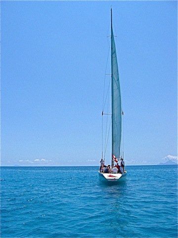 A sailboat is floating on top of a large body of water.