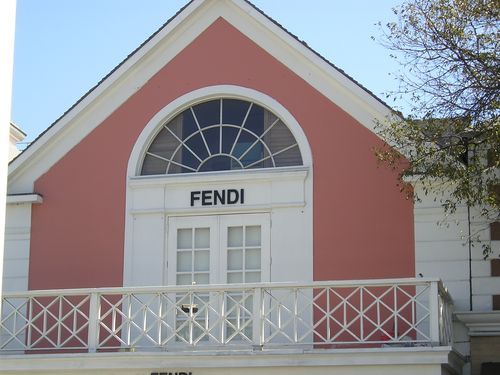 A building with a balcony and a sign that says fendi