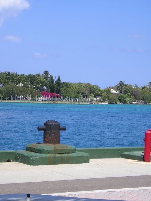 A large body of water with a red fire hydrant in the foreground