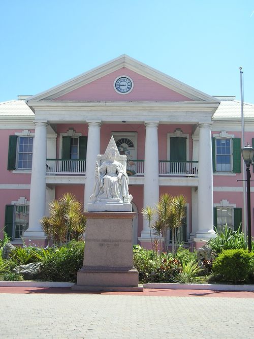 A large pink building with a statue in front of it