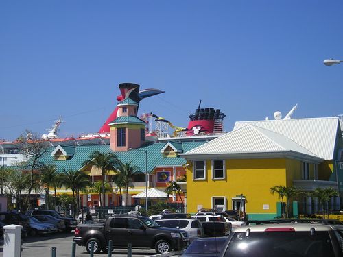 Cars are parked in front of a yellow building