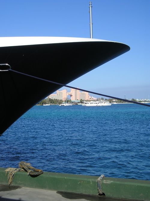 A boat is docked in the water with a city in the background