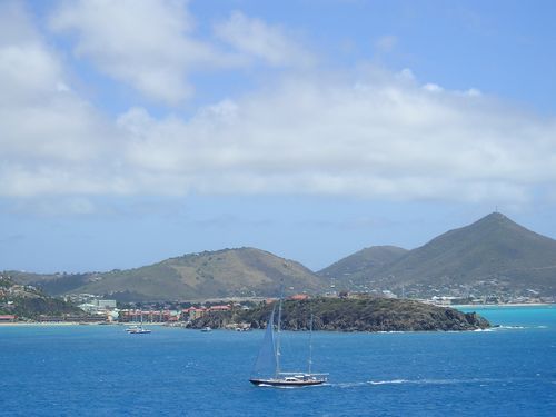 A sailboat in the ocean with mountains in the background