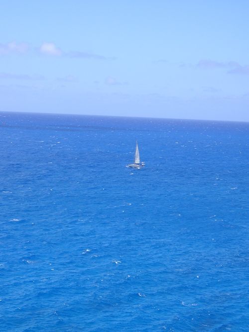 A sailboat is floating on top of a large body of water.