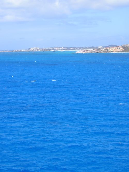 A large body of blue water with a small island in the distance.