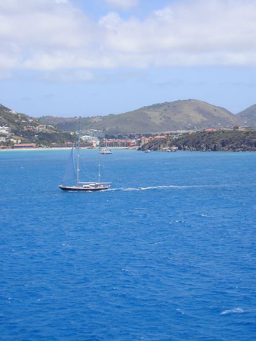 A sailboat is floating on top of a large body of water.