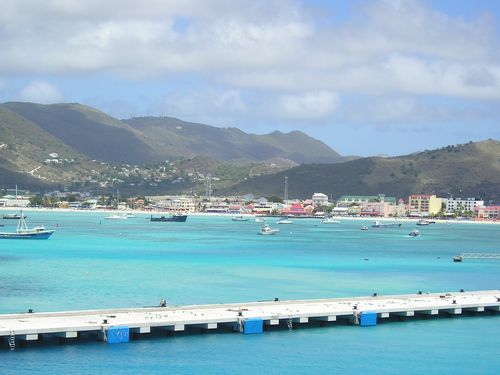 A dock in the middle of a body of water with mountains in the background
