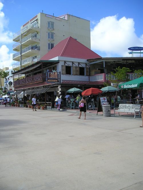 A group of people are walking in front of a building that says heineken