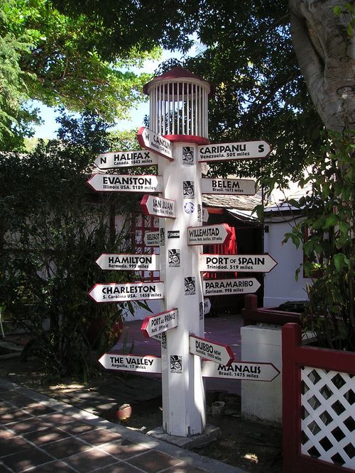 A pole with many signs on it including one that says hamilton