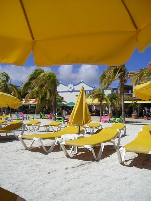 A beach with yellow chairs and yellow umbrellas