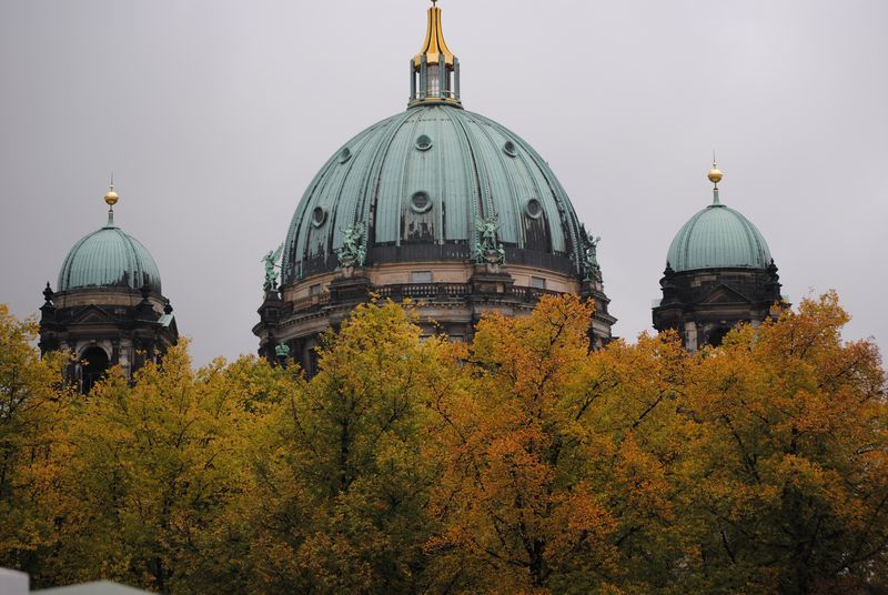 A dome on top of a building with trees in the foreground.