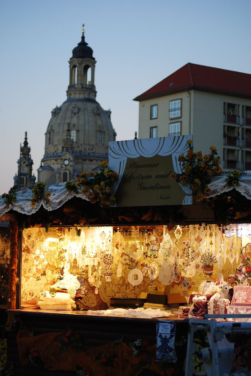 A christmas market with a tower in the background