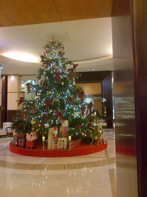 A large christmas tree with gifts underneath it