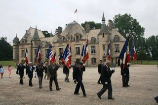 A group of people marching with flags in front of a large building