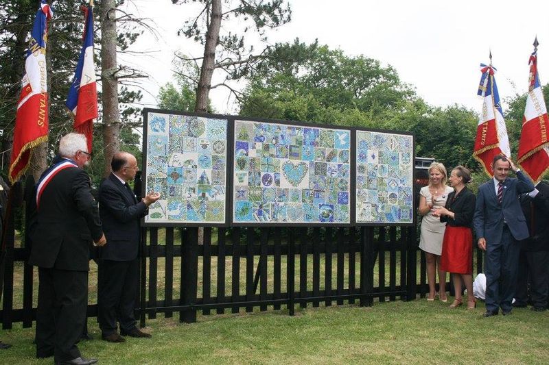 A group of people standing in front of a fence with flags