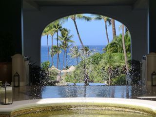 A pool with a view of the ocean and palm trees