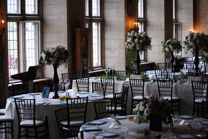 A large room with tables and chairs set up for a wedding reception