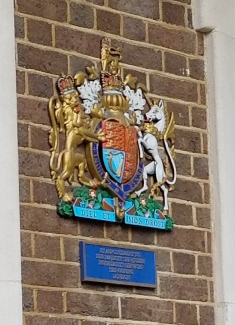 A brick wall with a coat of arms on it