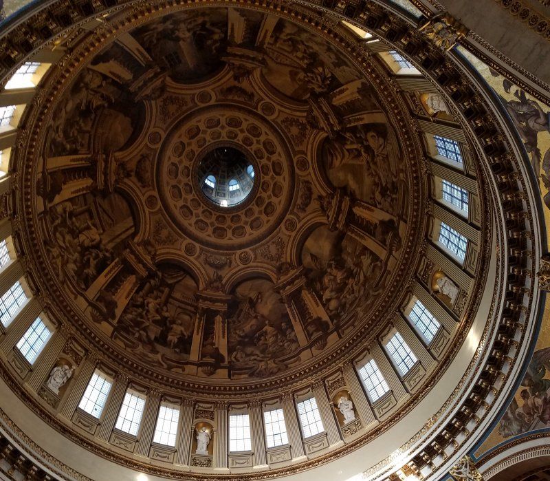 Looking up at the dome of a building with many windows