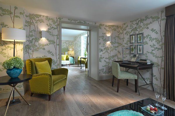 A living room with a green chair and a desk