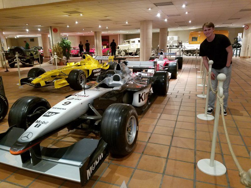 A man stands in front of a row of race cars