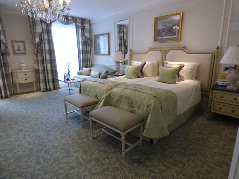 A hotel room with two beds and a chandelier