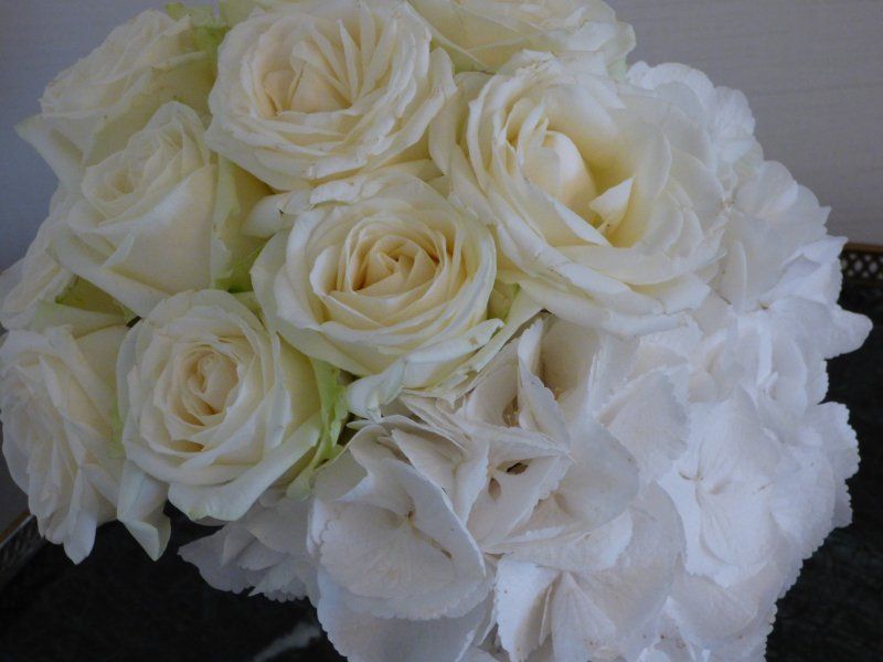 A bouquet of white roses and white hydrangea flowers