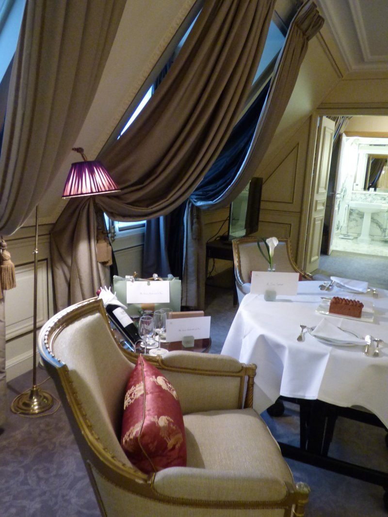 A chair with a red pillow sits in a room next to a table