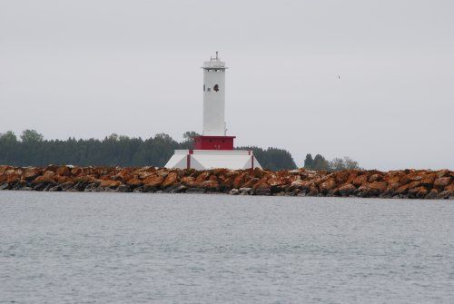 A red and white lighthouse in the middle of a body of water