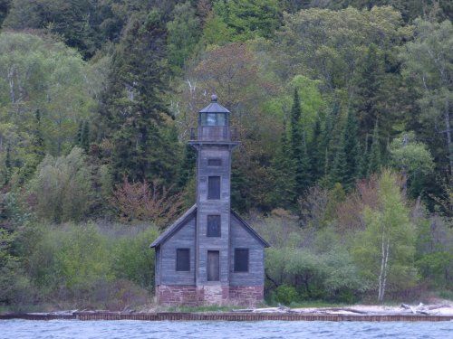 A lighthouse on a small island in the middle of a lake