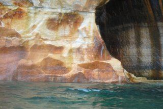 A large rock in the middle of a body of water.