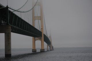 A bridge over a body of water on a foggy day.