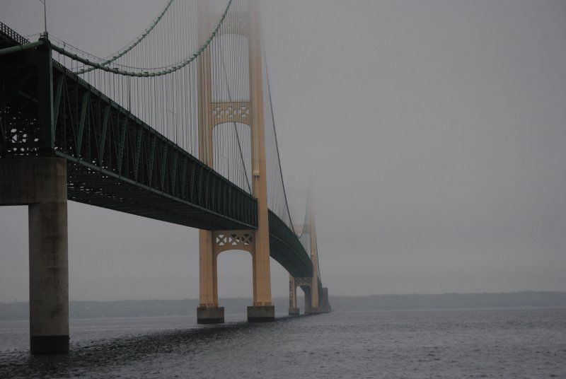 A bridge over a body of water on a foggy day.