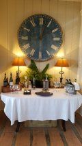 A table with a white tablecloth and a large clock on the wall.