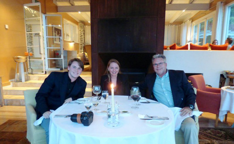 Two men and a woman are sitting at a table in a restaurant.