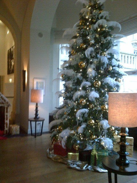 A living room with a christmas tree and a lamp