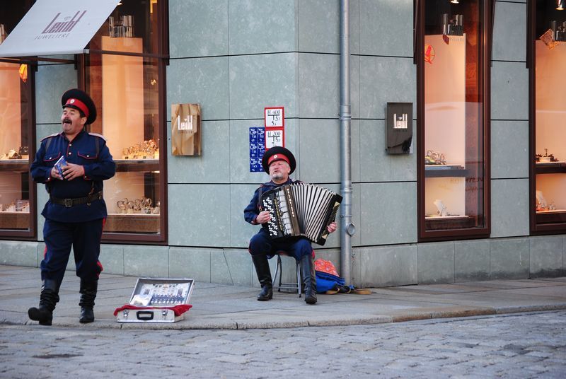 A man is playing an accordion in front of a store