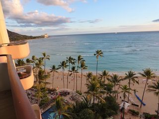 A view of a beach and ocean from a balcony.