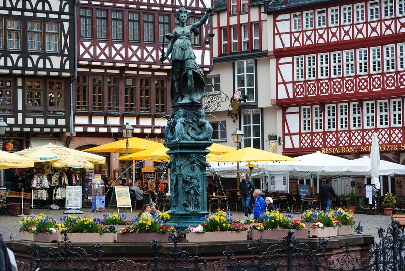 A fountain with a statue on top of it in front of a building
