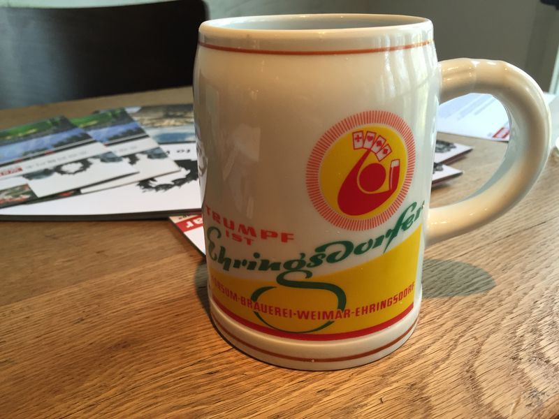 A mug that says schwingsdorf is on a wooden table