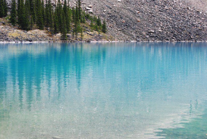 A lake with a mountain in the background and trees reflected in the water.