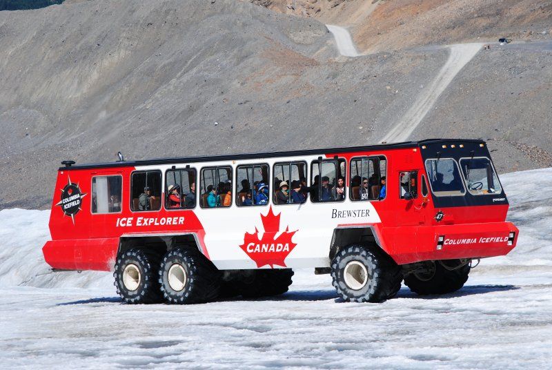 A red and white bus that says ice explorer on the side