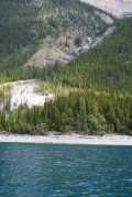 A lake with mountains in the background and trees on the shore.