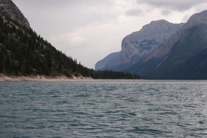 A lake with mountains in the background and trees on the shore.