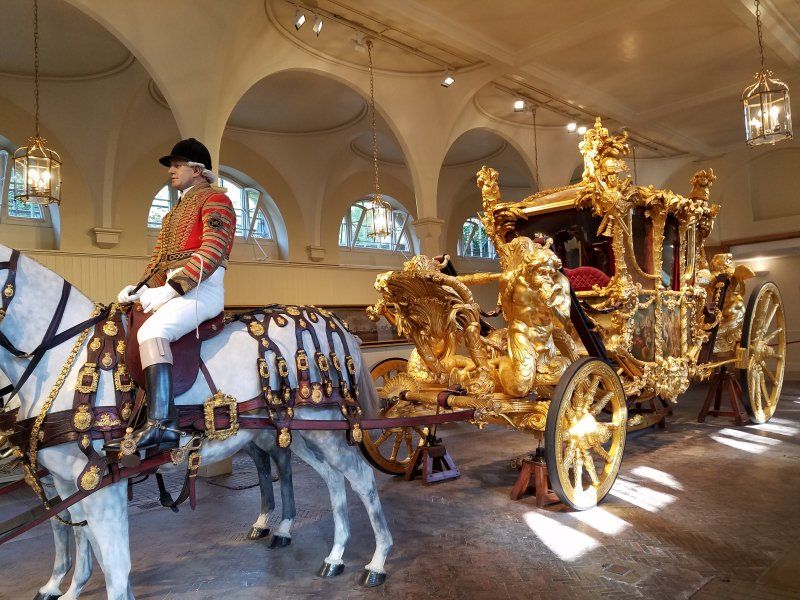A man is riding a horse drawn carriage in a building.