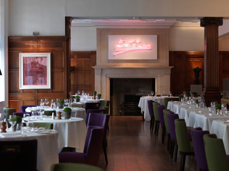 A dining room with tables and chairs and a sign that says a cup of milkshakes