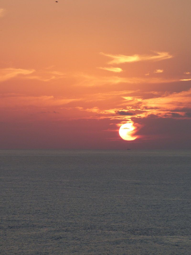 The sun is setting over the ocean.